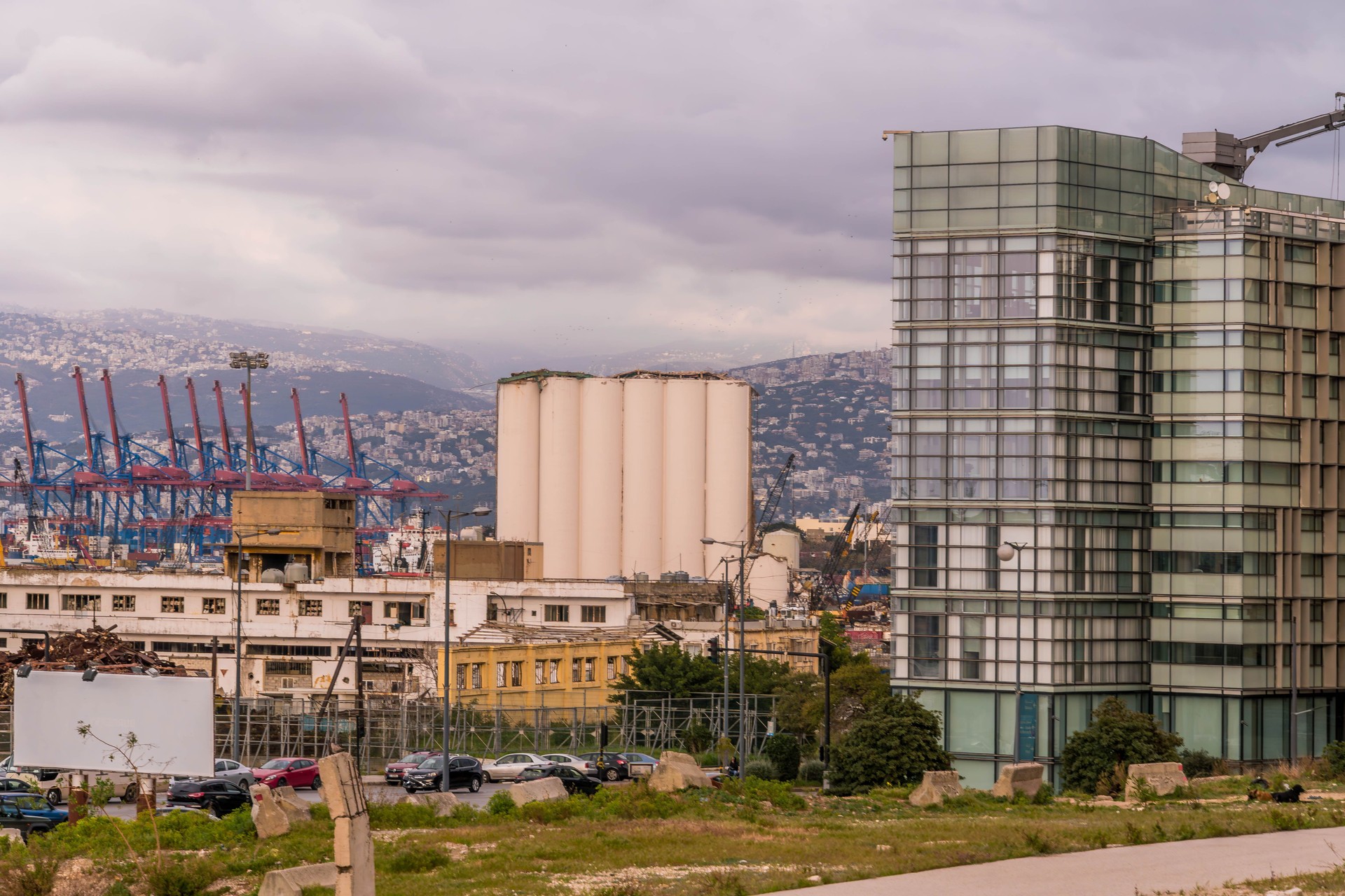 Panoramic view of Beirut port, Lebanon, featuring industrial cranes, silo ruined after 2020 explosion, and surrounding urban architecture
